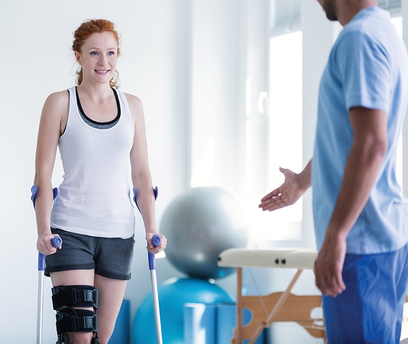 Woman Walking With Crutches During Physiotherapy