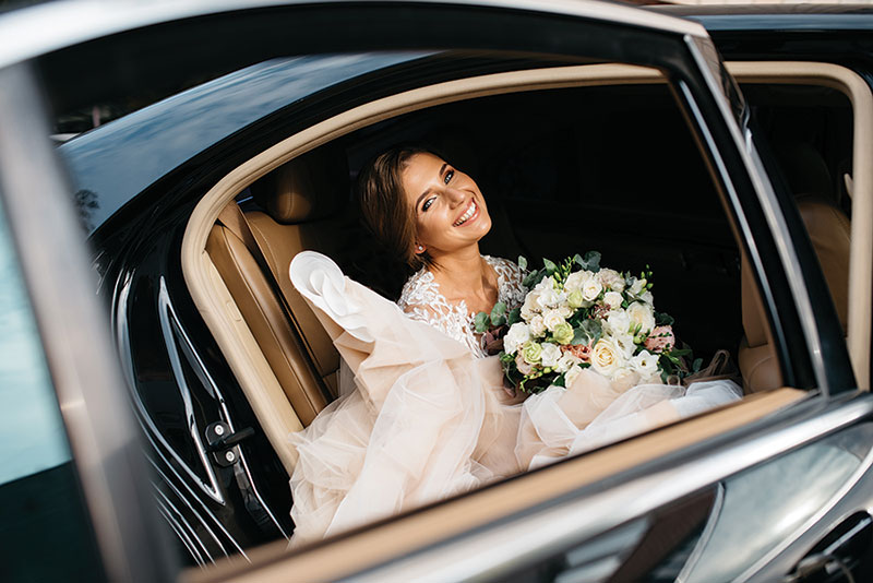 Smiling bride, getting out of car