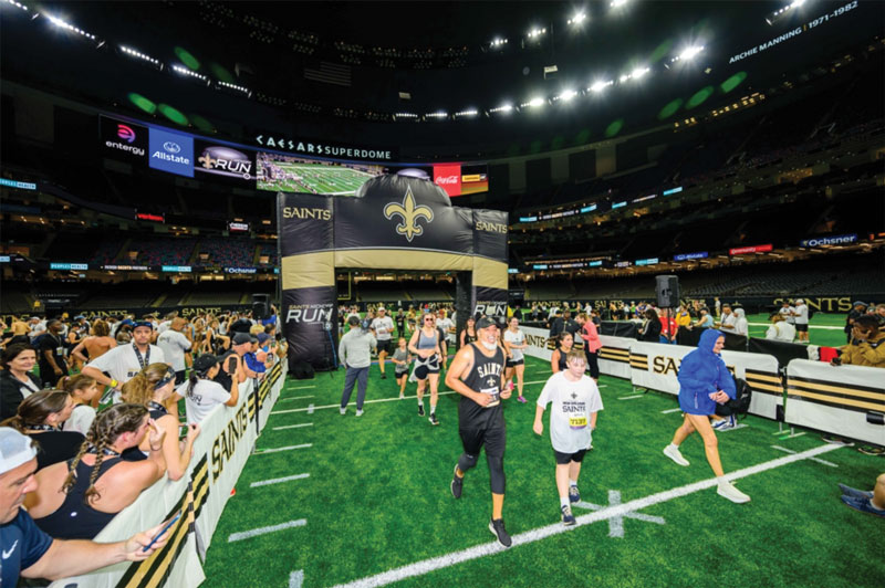 Group of people running into the Caesars Superdome