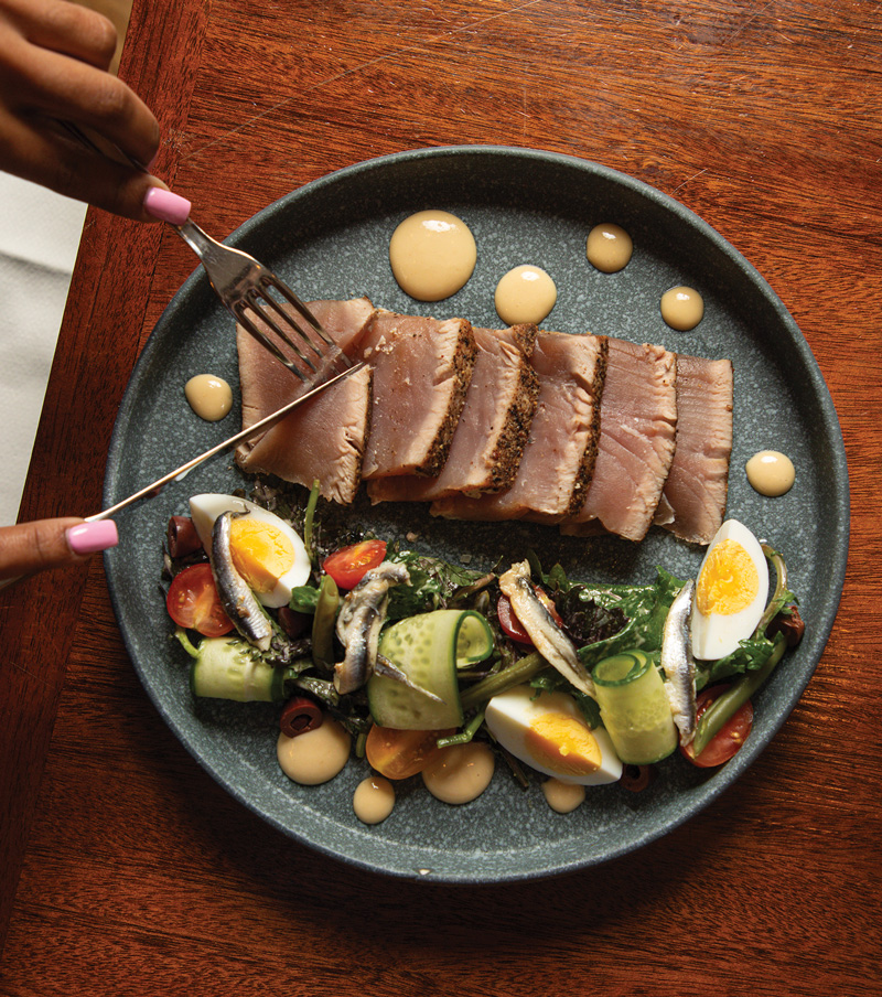 Hands cutting into food on a plate