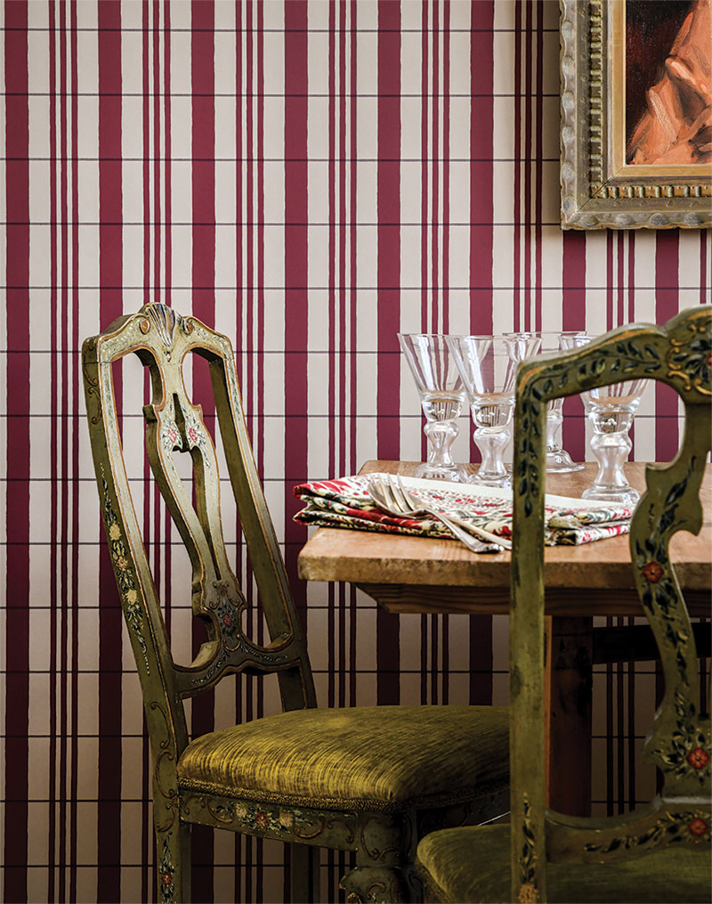 Red and white striped wallpaper. In front of the wallpaper is a dining table and set