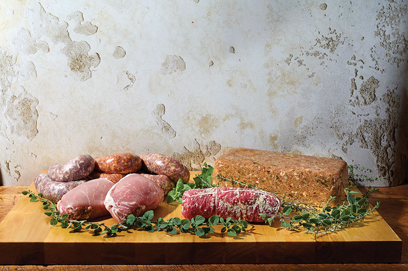A variety of meats, sausages laid out on a table