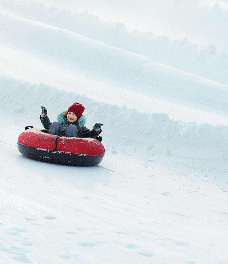 Heading North to Colorado for Carnival A young child tubing on the snow
