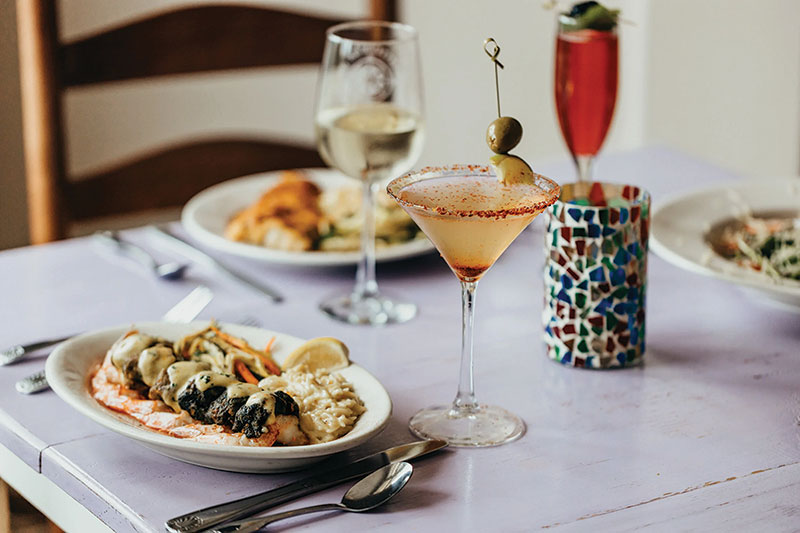 Southern Escapes Along the Gulf Coast A shot of dinner dishes on a set table with mixed drinks nearby