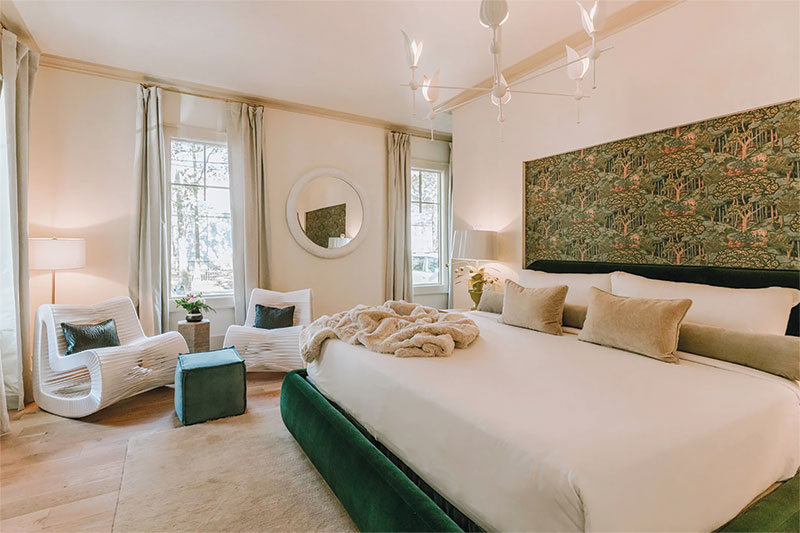 Southern Escapes Along the Gulf Coast Interior of a Springs Hotel room featuring a wallpapered backsplash headboard area and a velvet-covered bedframe
